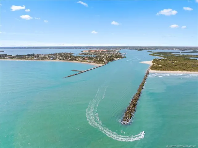 Dramatic aerial view looking through the Fort Pierce Inlet toward the Intracoastal, showcasing direct access between the Atlantic Ocean and surrounding waterways.