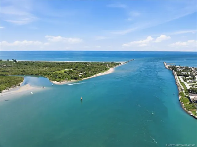 Aerial view showcases the community along the Intracoastal with nearby docks, waterfront homes, and the Fort Pierce Inlet leading to the Atlantic.