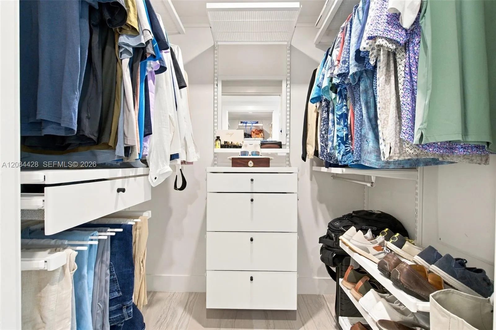 First of two separate custom-fitted walk-in closets with built-in drawers and hanging storage. Closets will be cleared for tenant use.