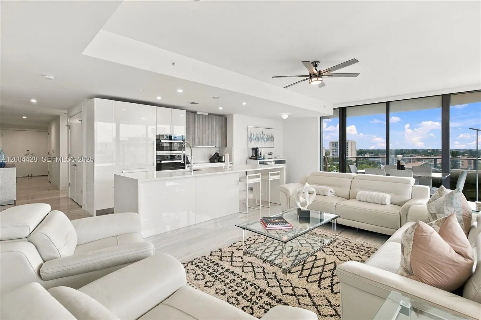 Spacious open-concept living room and kitchen with floor-to-ceiling glass.