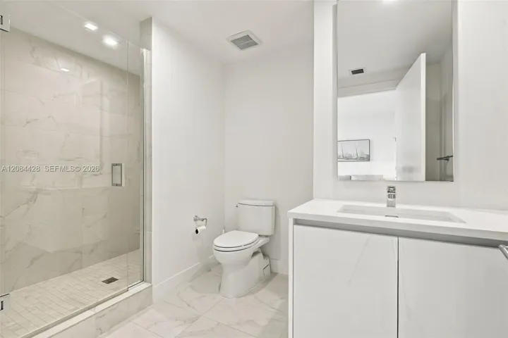 Guest bathroom with a glass-enclosed walk-in shower.