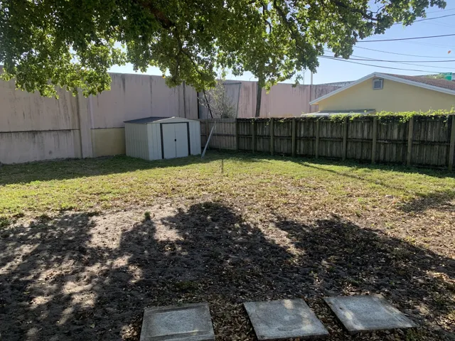 Large fenced yard with Utility Shed