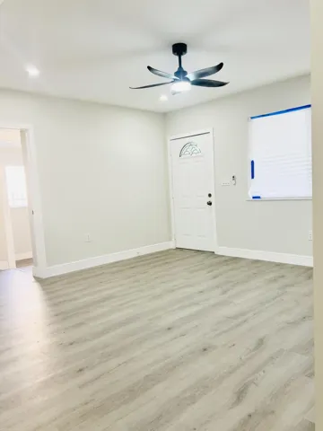 Living Room, with warm toned new flooring and windows.