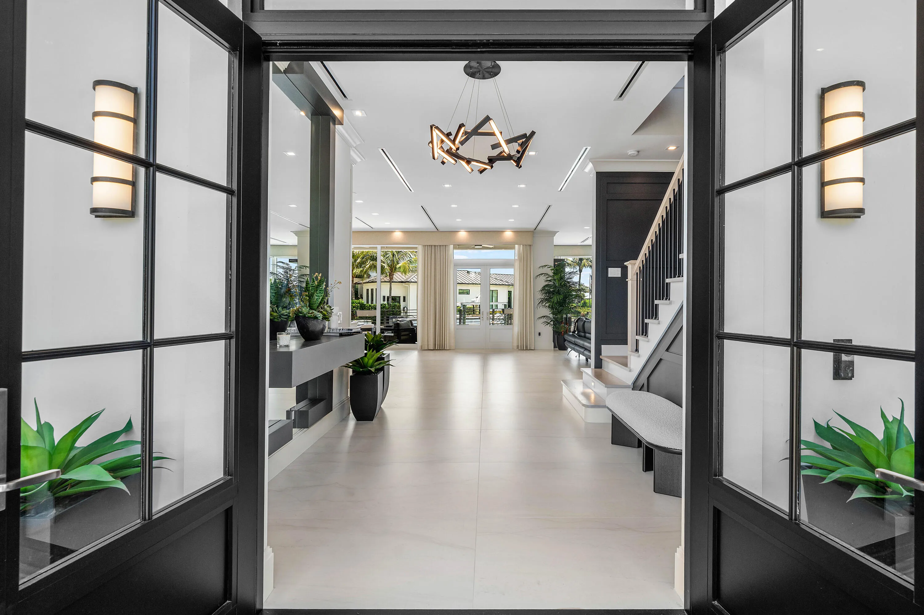 Grand foyer featuring a modern chandelier, recessed lighting, a built-in console, elegant staircase, and expansive tile flooring