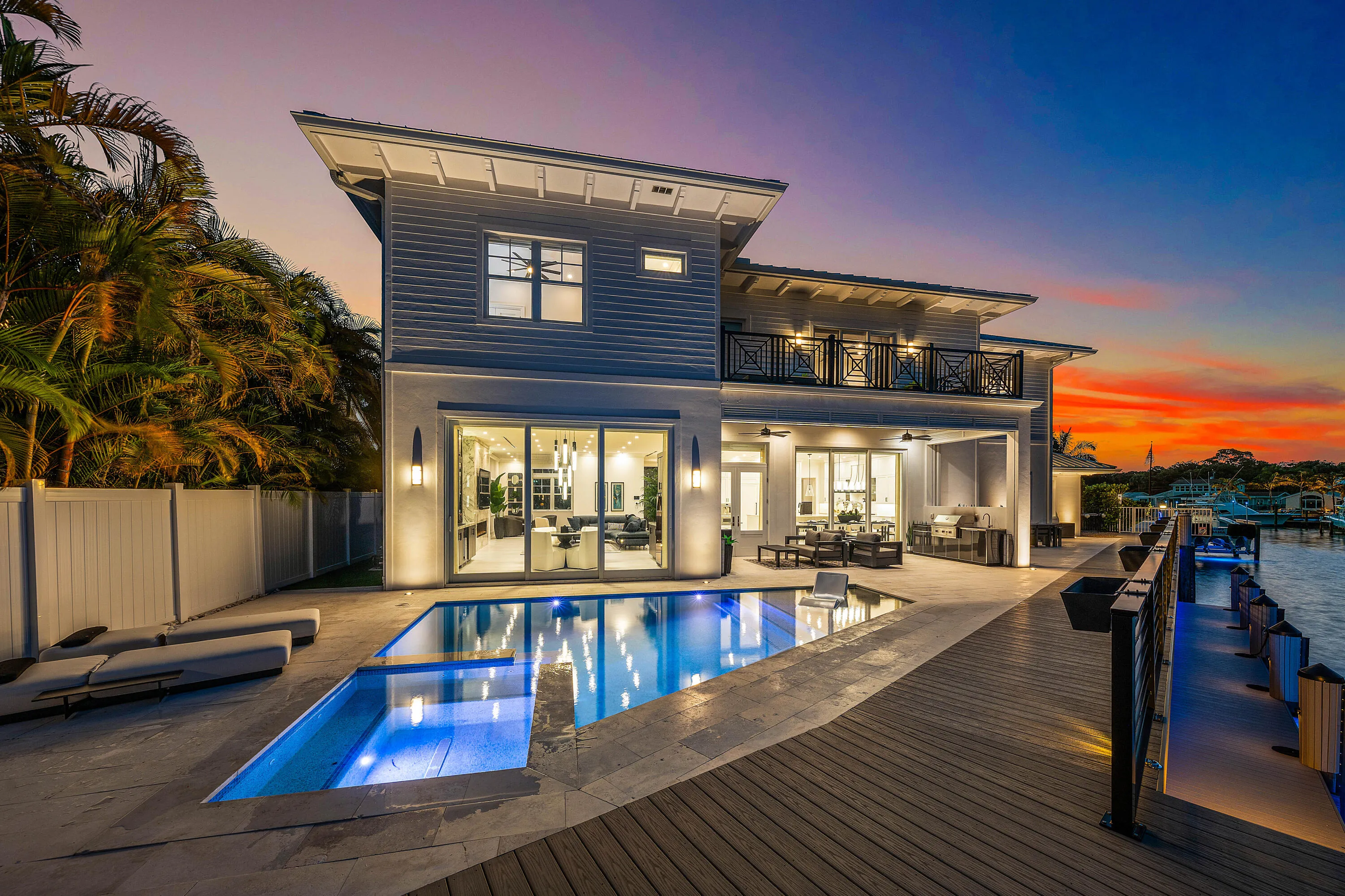 Contemporary exterior with a private swimming pool, expansive paved patio, and a wood-plank dock