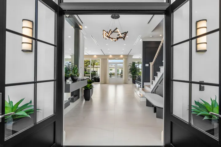 Grand foyer featuring a modern chandelier, recessed lighting, a built-in console, elegant staircase, and expansive tile flooring