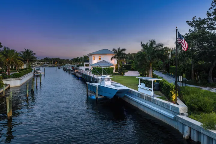 Waterfront property featuring a private boat lift, concrete seawall