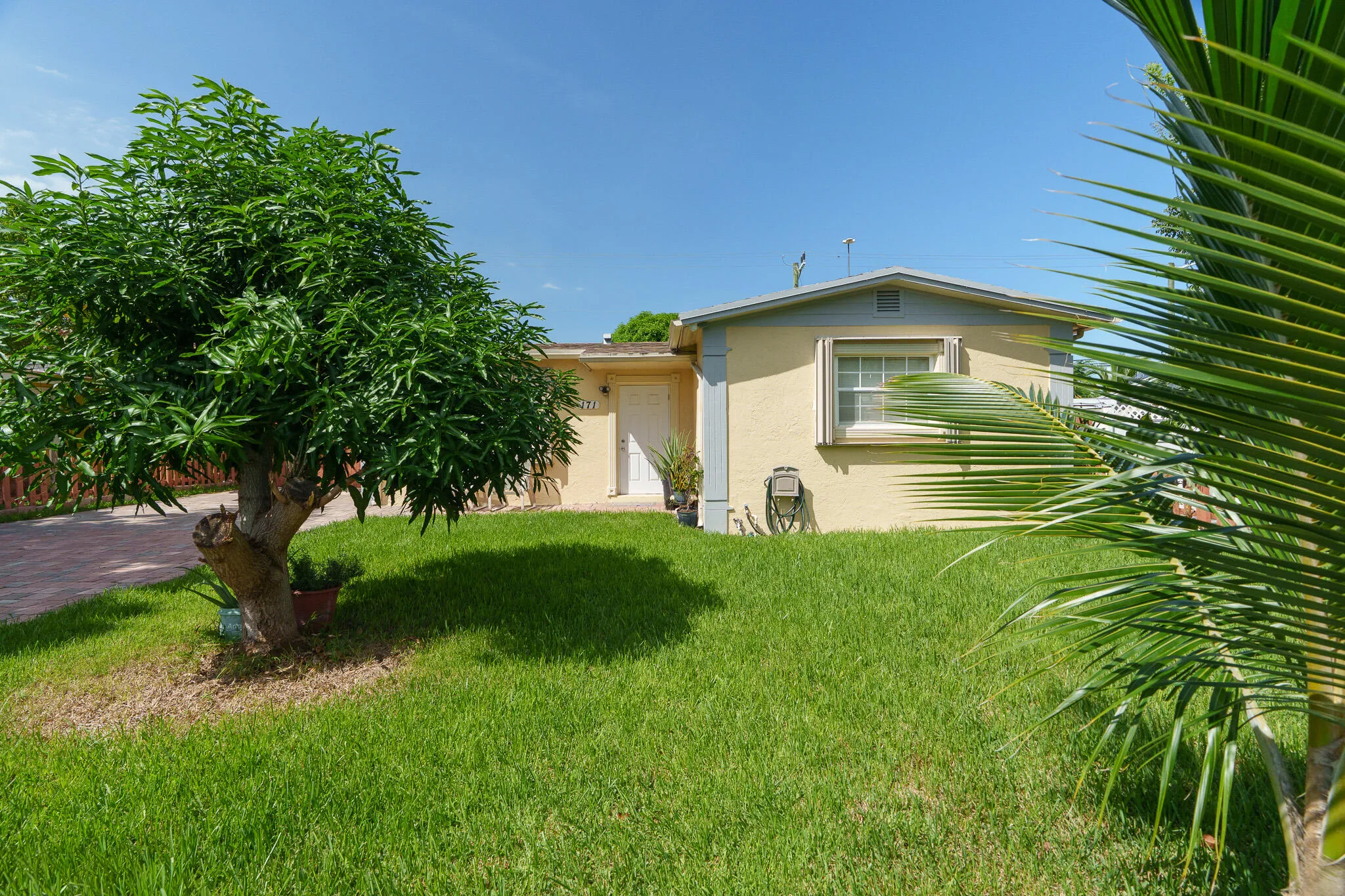 Exterior featuring stucco siding, a pitched roof, a front door, and a single window