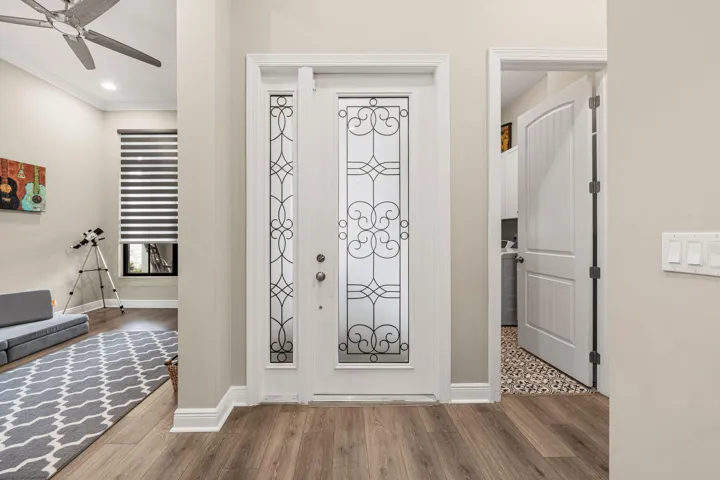 Frosted glass entry door with decorative ironwork, and crown molding
