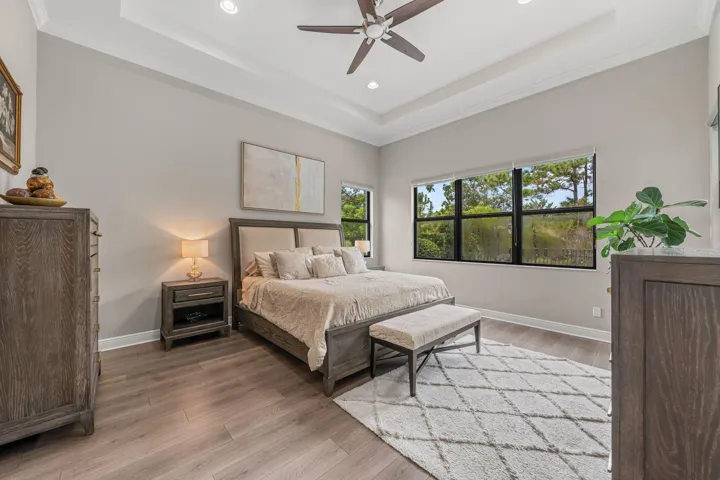 Bright and spacious primary suite with tray ceilings, recessed lighting and crown molding