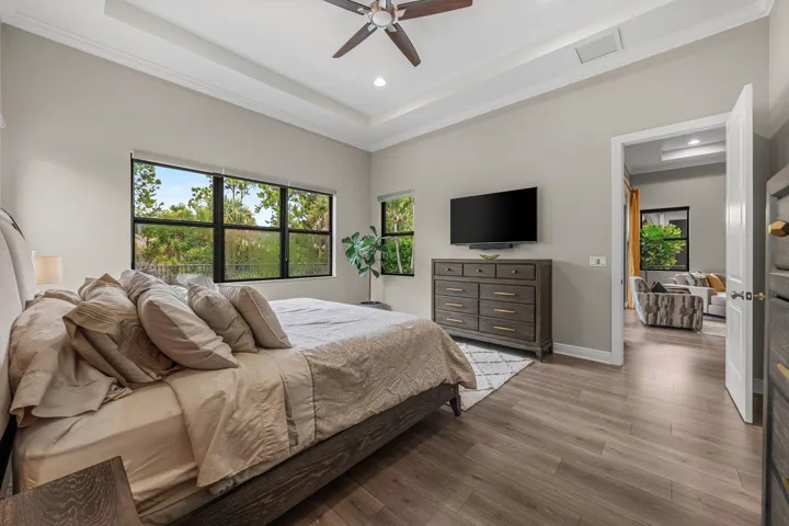Tray ceiling with crown molding, recessed lighting, and a ceiling fan