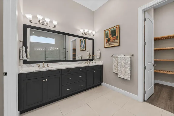 Dual vanity with dark cabinetry, undermount sinks, and light-toned countertops
