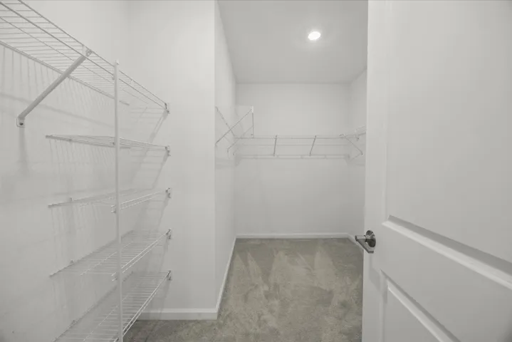 Walk-in closet with carpet flooring, recessed lighting, and white wire shelving