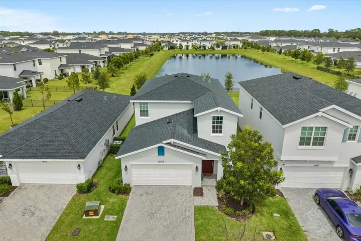 Aerial perspective showcasing multiple homes with dark shingle roofing, light-colored exteriors, and attached garages