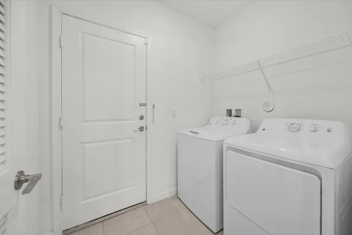 Laundry area with tile flooring and overhead wire shelving