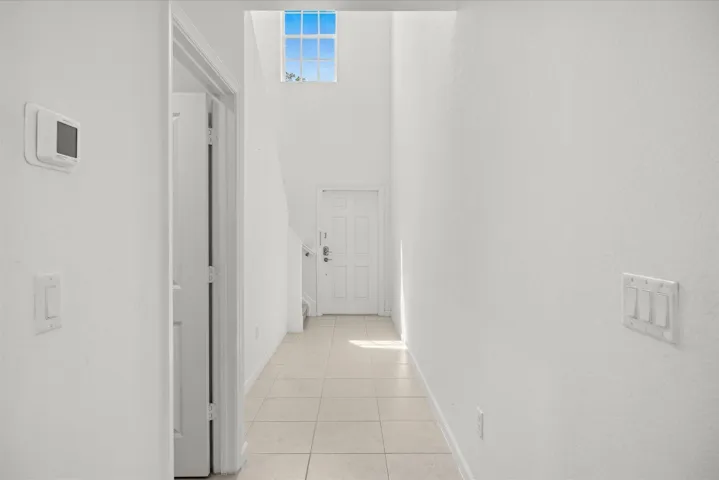 Two-story foyer with transom window, tile flooring, and white interior doors
