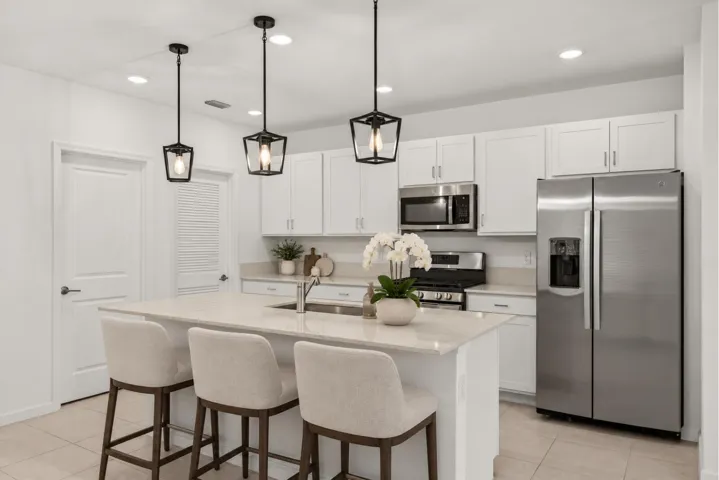 Kitchen featuring a center island with sink, stainless steel appliances, white cabinetry, and recessed lighting