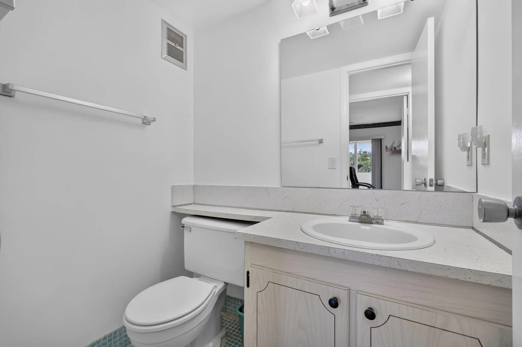 Vanity with integrated sink, speckled countertop, and white cabinetry