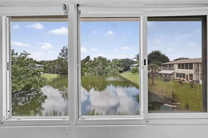Triple sliding glass doors with a pond and landscape beyond