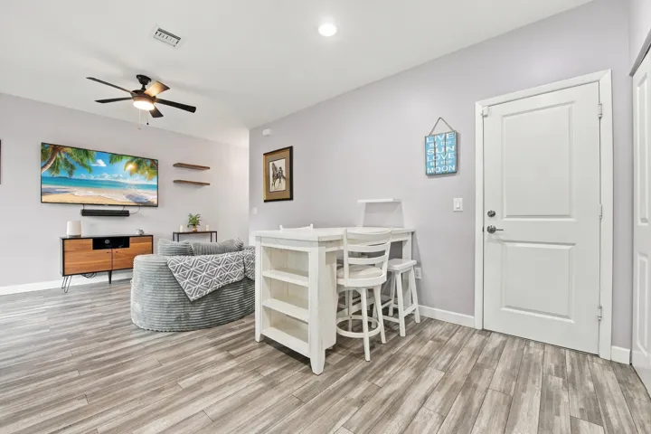 Wood-finish flooring throughout, recessed lighting, and a ceiling fan with integrated lighting