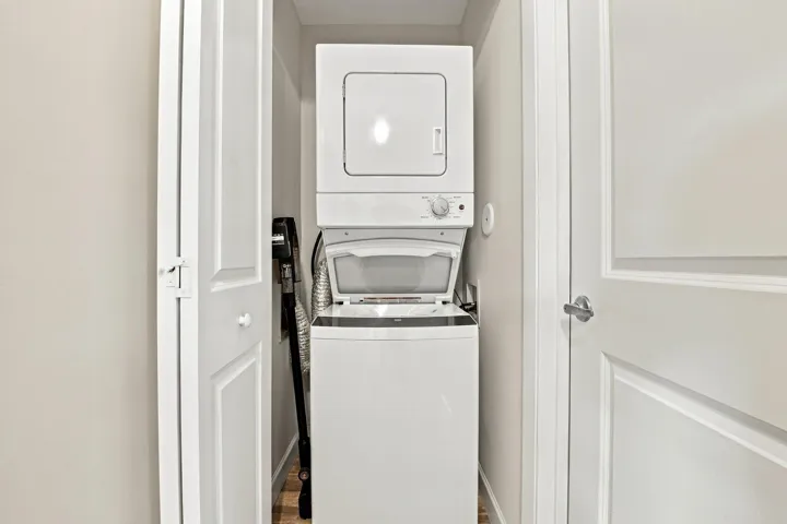 White stackable washer and dryer within a dedicated utility closet