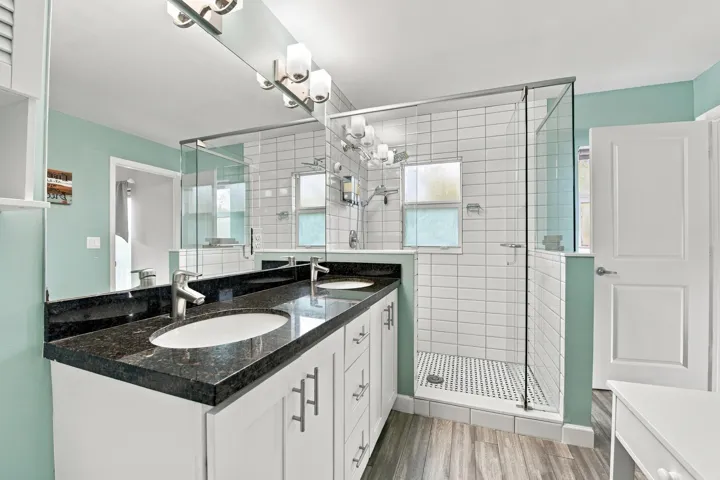 Dual vanity with dark stone countertop and undermount sinks