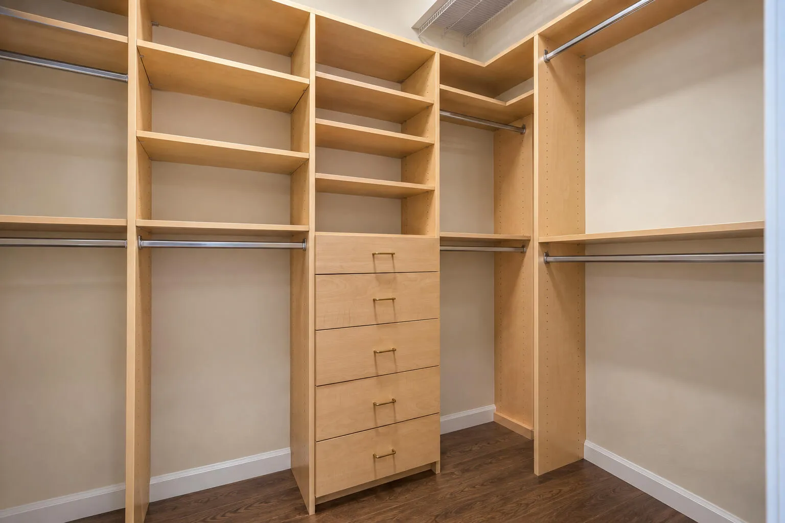 Well-organized walk-in closet with extensive built-in shelving and drawers for maximizing storage.
