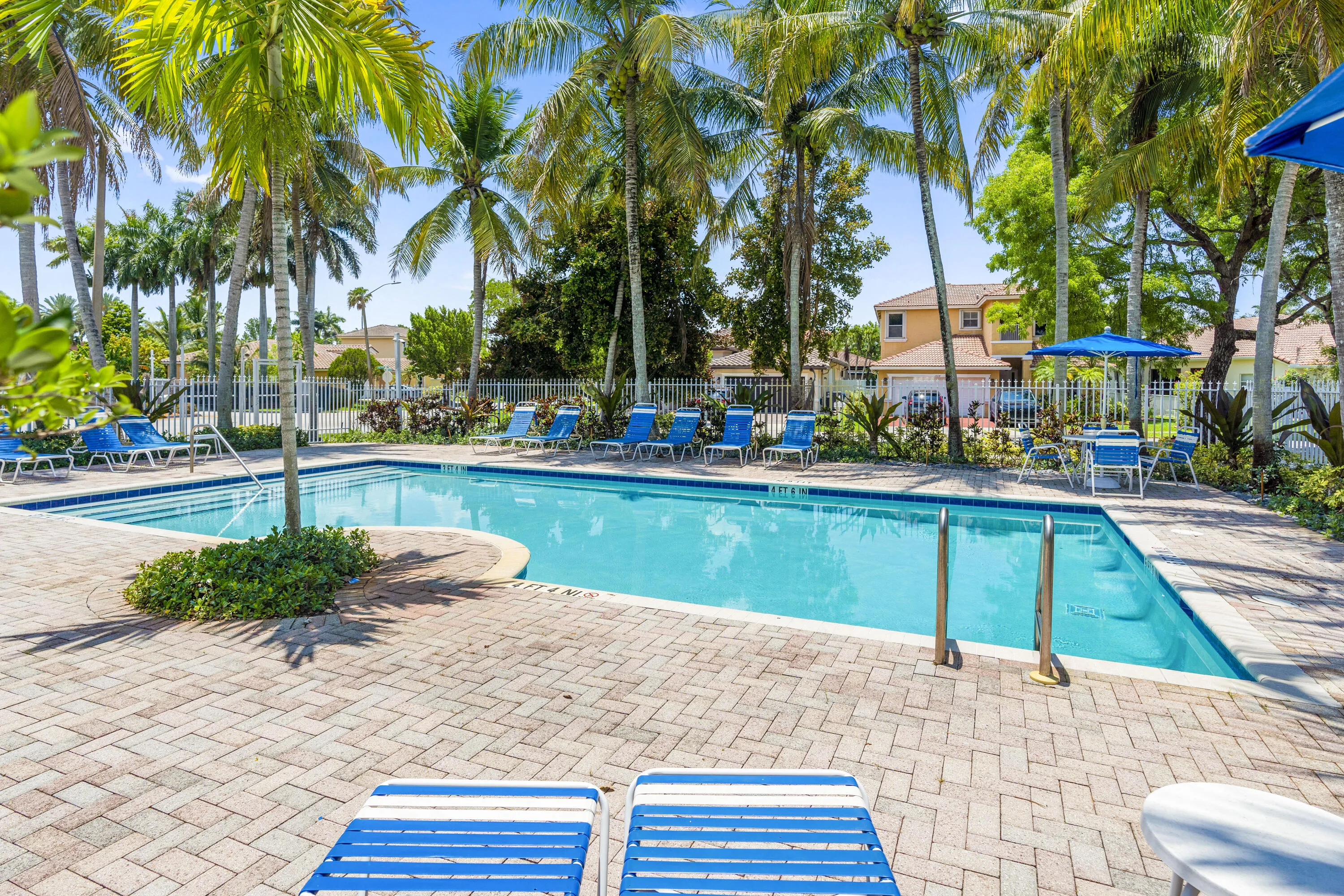 Mariposa Isles community pool area with surrounding lounge space and playground.
