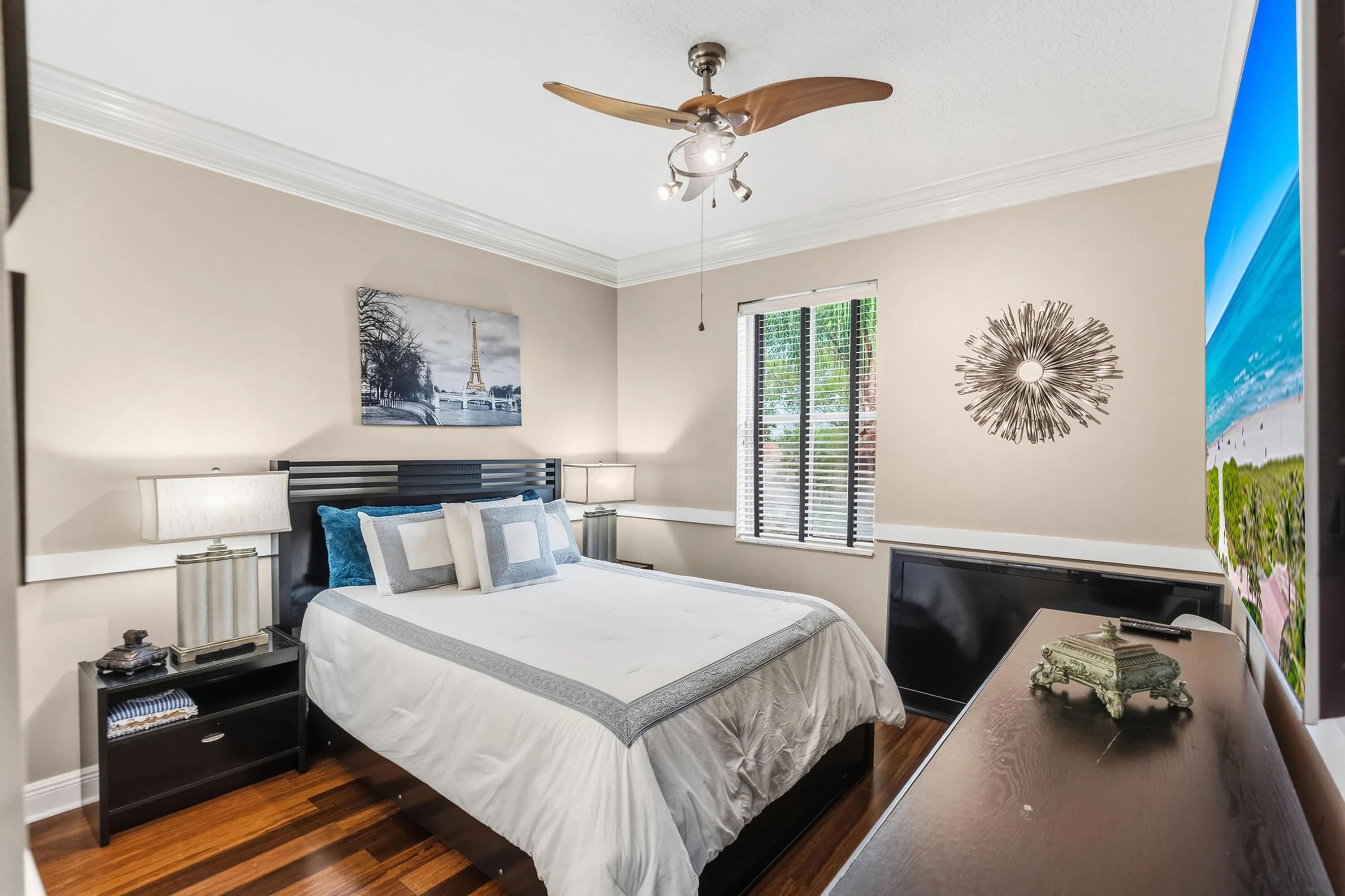 Spacious upstairs bedroom with wood flooring, crown molding and room for a queen-size bed.