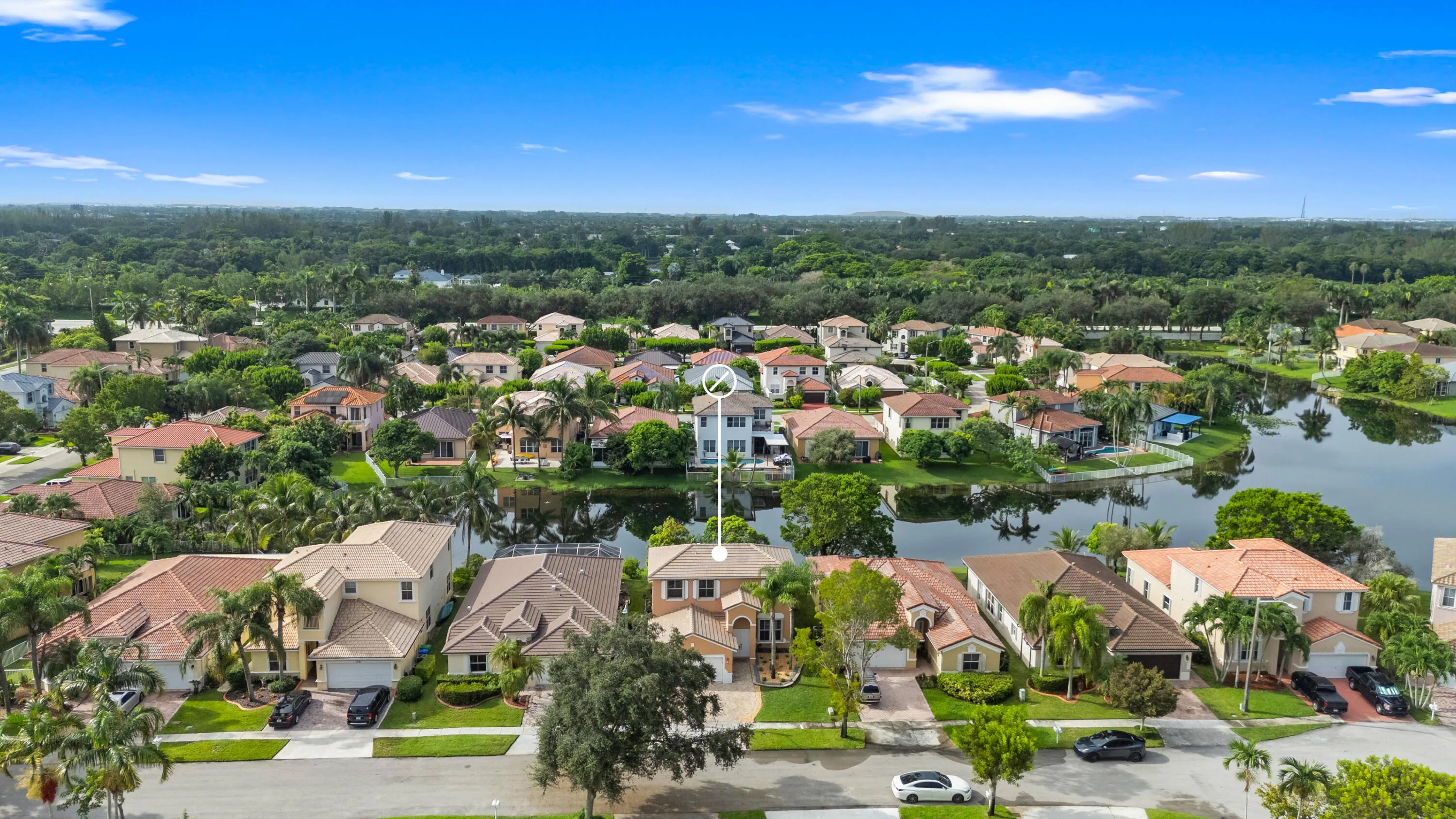 Elevated front view showing the home’s residential setting with the lake directly behind the property.