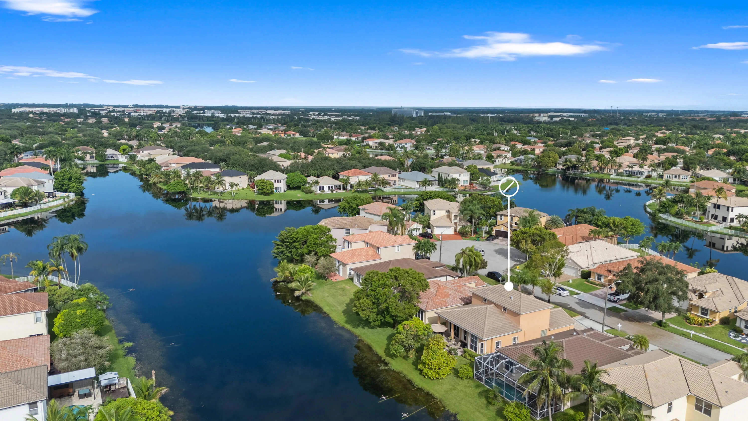 Expansive aerial perspective showcasing the home’s waterfront location and the scenic lake-filled community.
