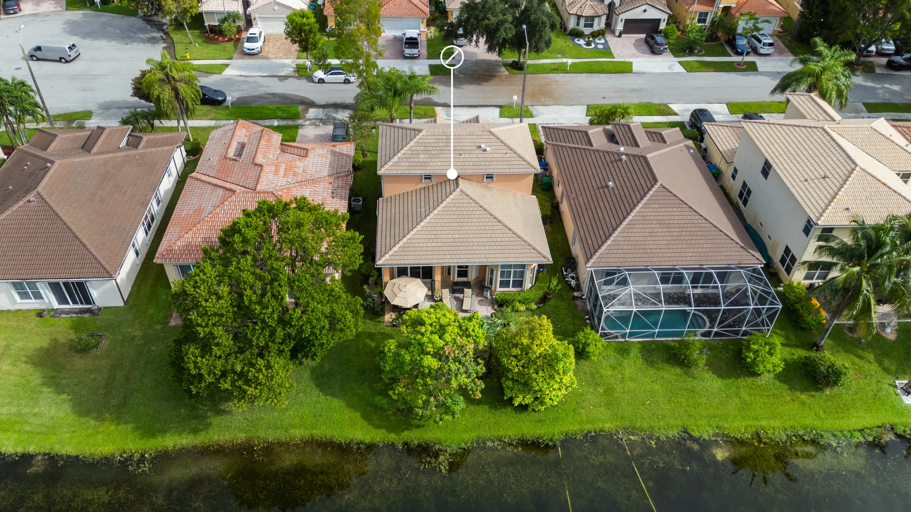 Aerial view from the lake showcasing the home, backyard and direct waterfront setting within the neighborhood.
