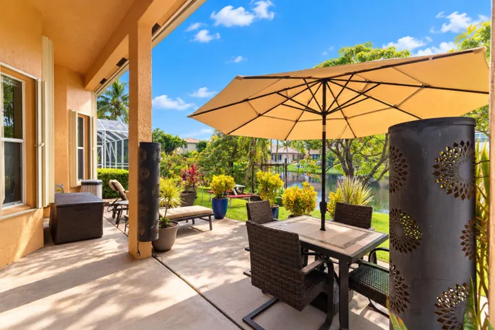 Spacious backyard with lush landscaping and a covered patio overlooking the lake.