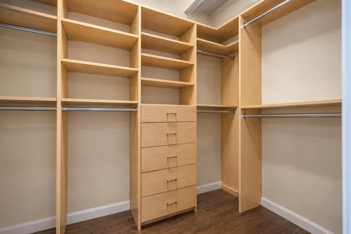 Well-organized walk-in closet with extensive built-in shelving and drawers for maximizing storage.