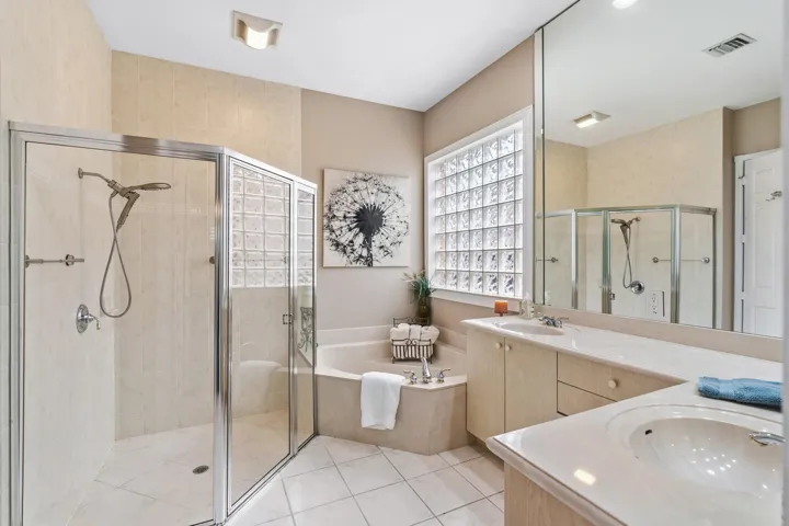 Primary bath features dual vanities, a separate shower and soaking tub.