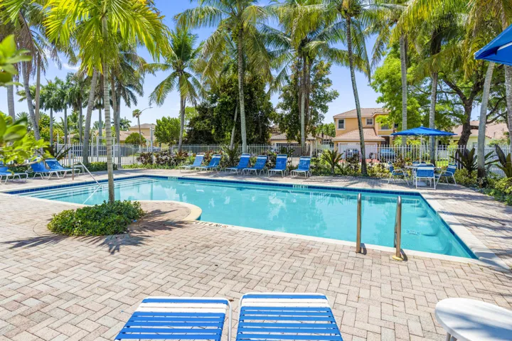 Mariposa Isles community pool area with surrounding lounge space and playground.