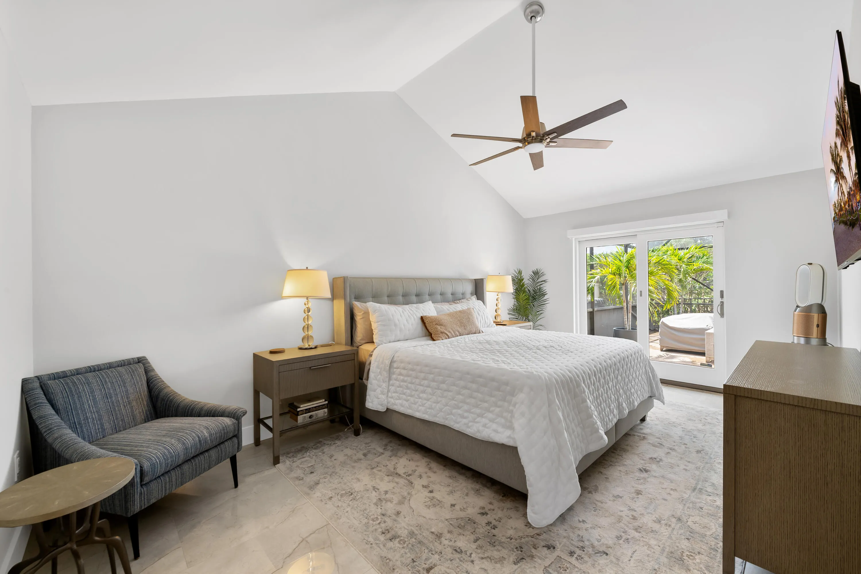 Vaulted ceiling with a ceiling fan, sliding glass doors to outdoor patio, and hard surface flooring