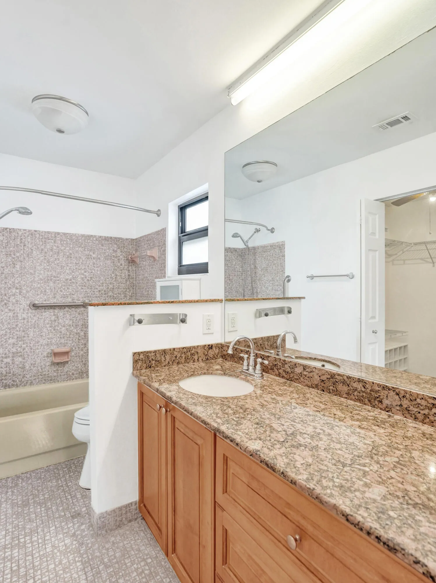 Vanity with dual integrated sinks, granite countertop, and wood-finish cabinetry