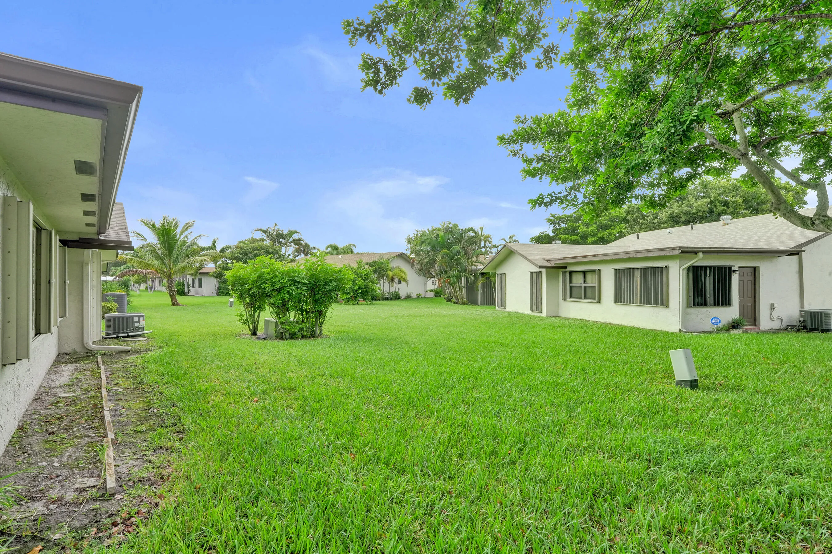 Expansive green lawn with mature trees and landscaping