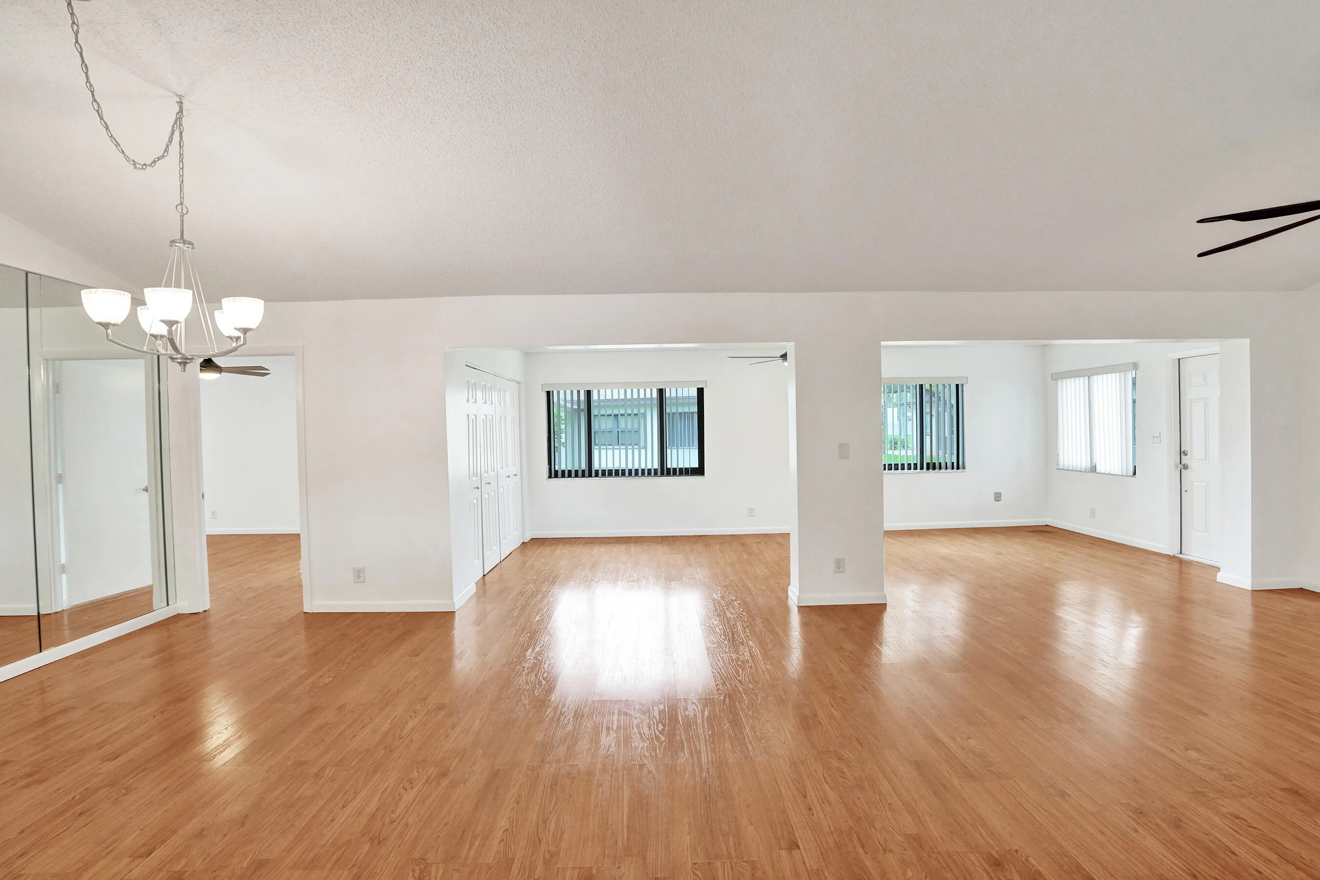 Expansive interior featuring wood-finish flooring, white walls, and multiple windows