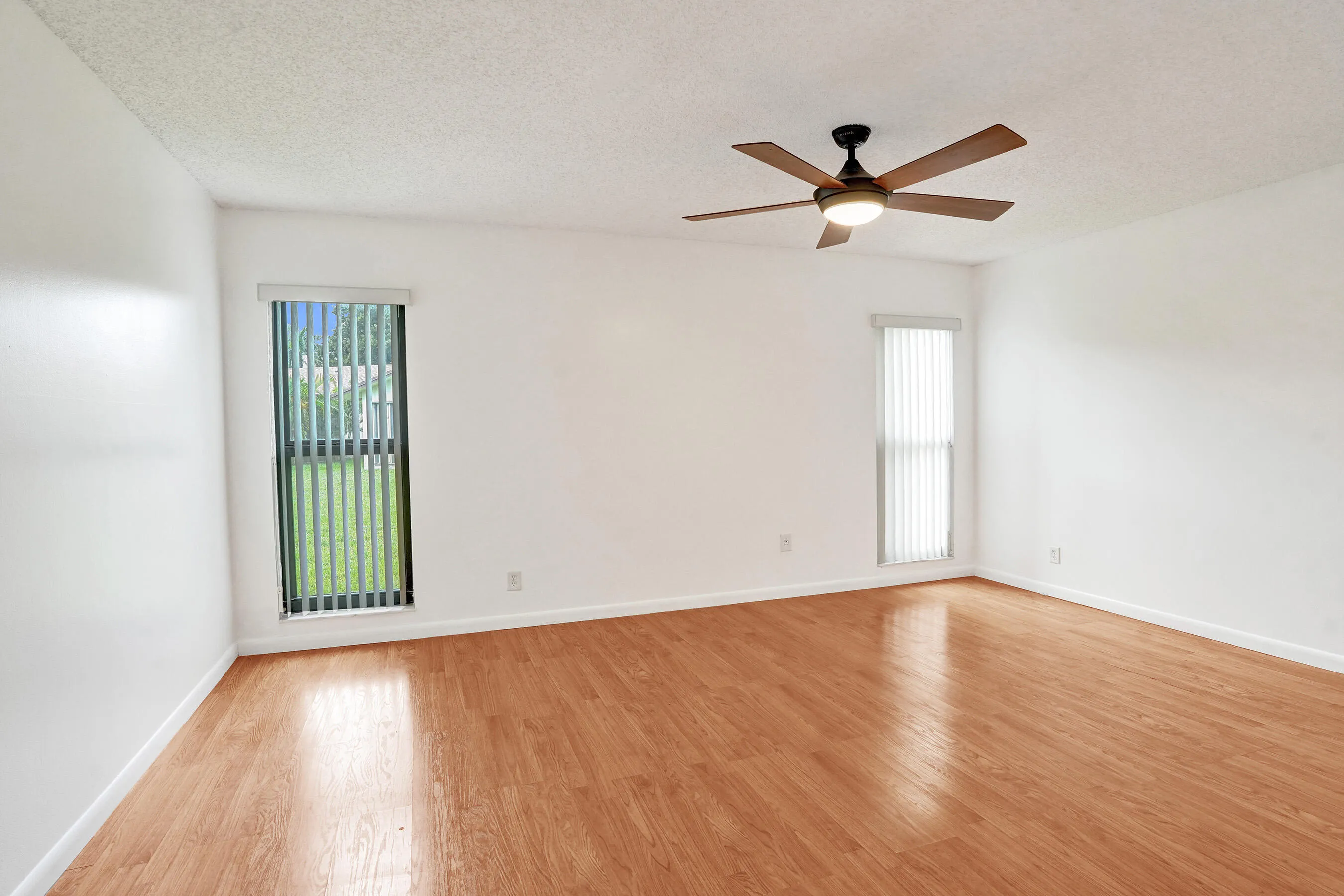 Wood-finish flooring with white walls and a textured ceiling
