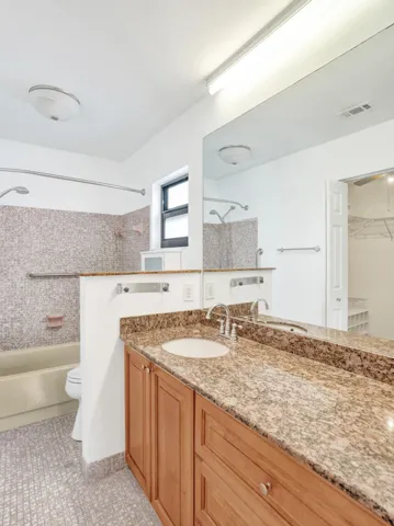 Vanity with dual integrated sinks, granite countertop, and wood-finish cabinetry