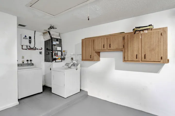 Utility area with wood-finish cabinetry and a flat white ceiling