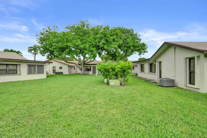 Expansive green lawn with mature trees and low-maintenance landscaping