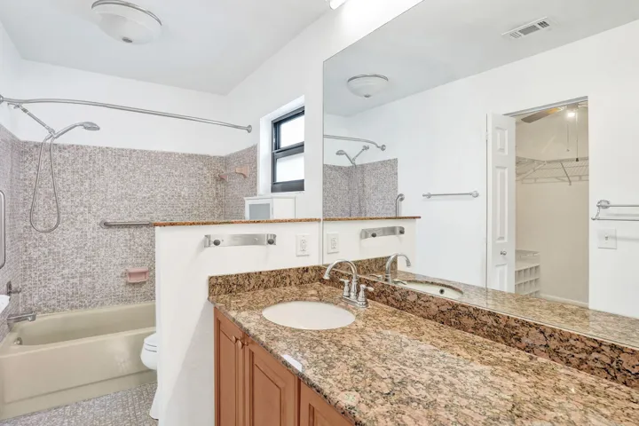 Wood-finish cabinetry with a granite-style countertop and integrated sink