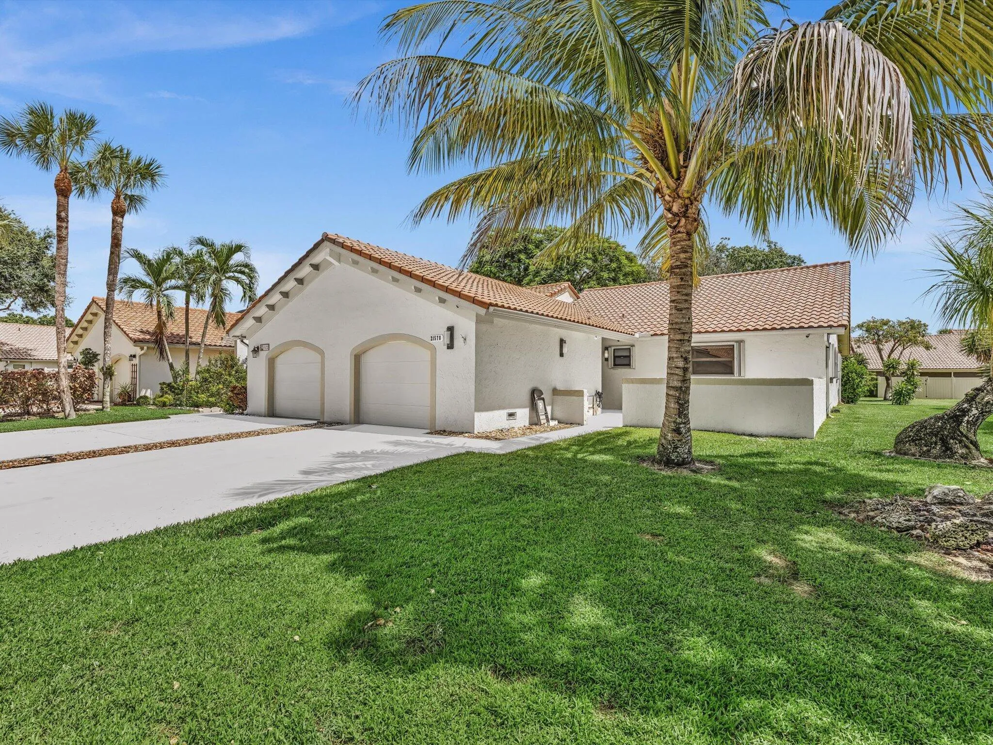 Stucco exterior with a tile roof, two-car garage, and a concrete driveway