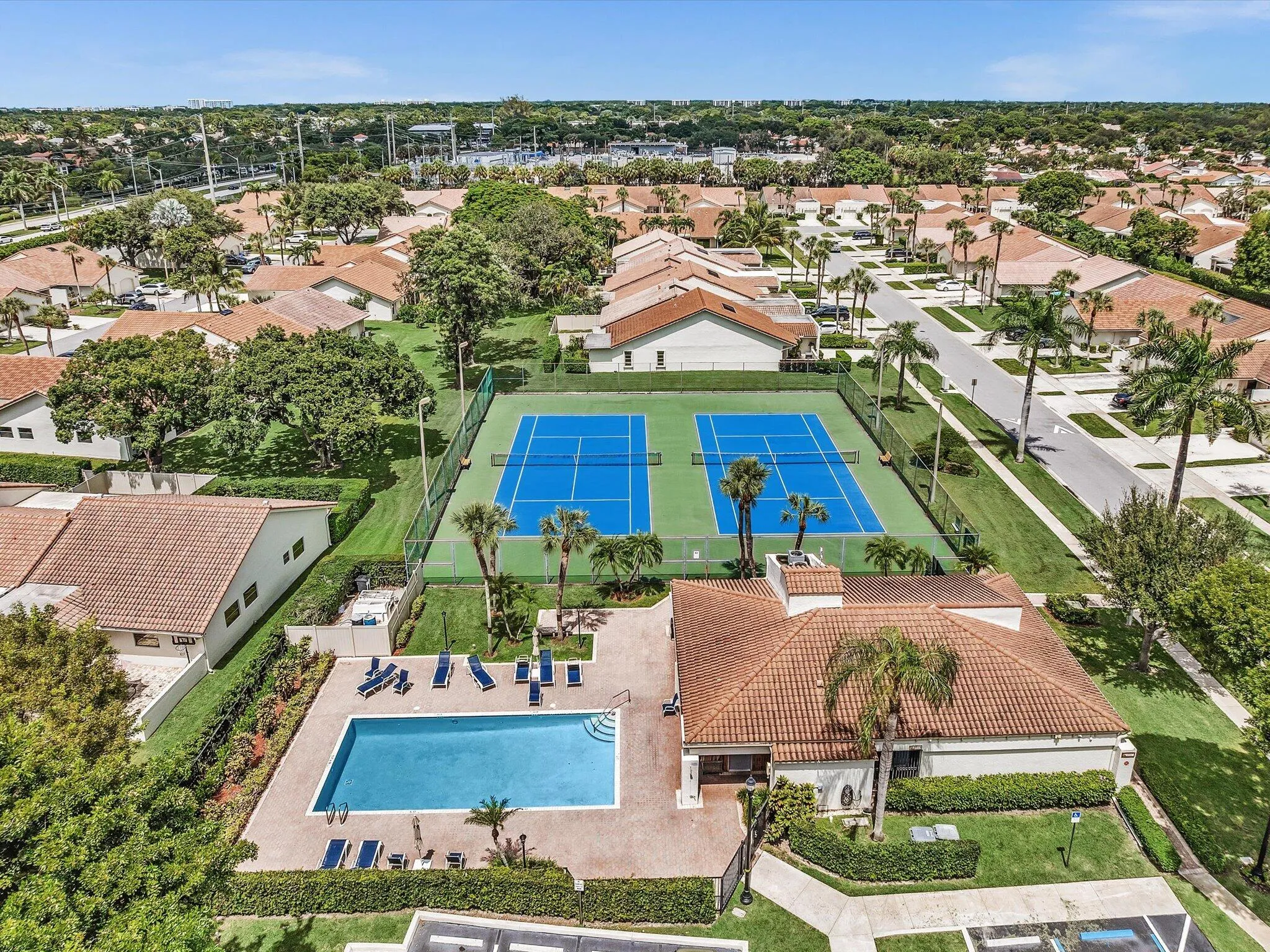 Community amenities featuring two tennis courts, a swimming pool, and a clubhouse structure