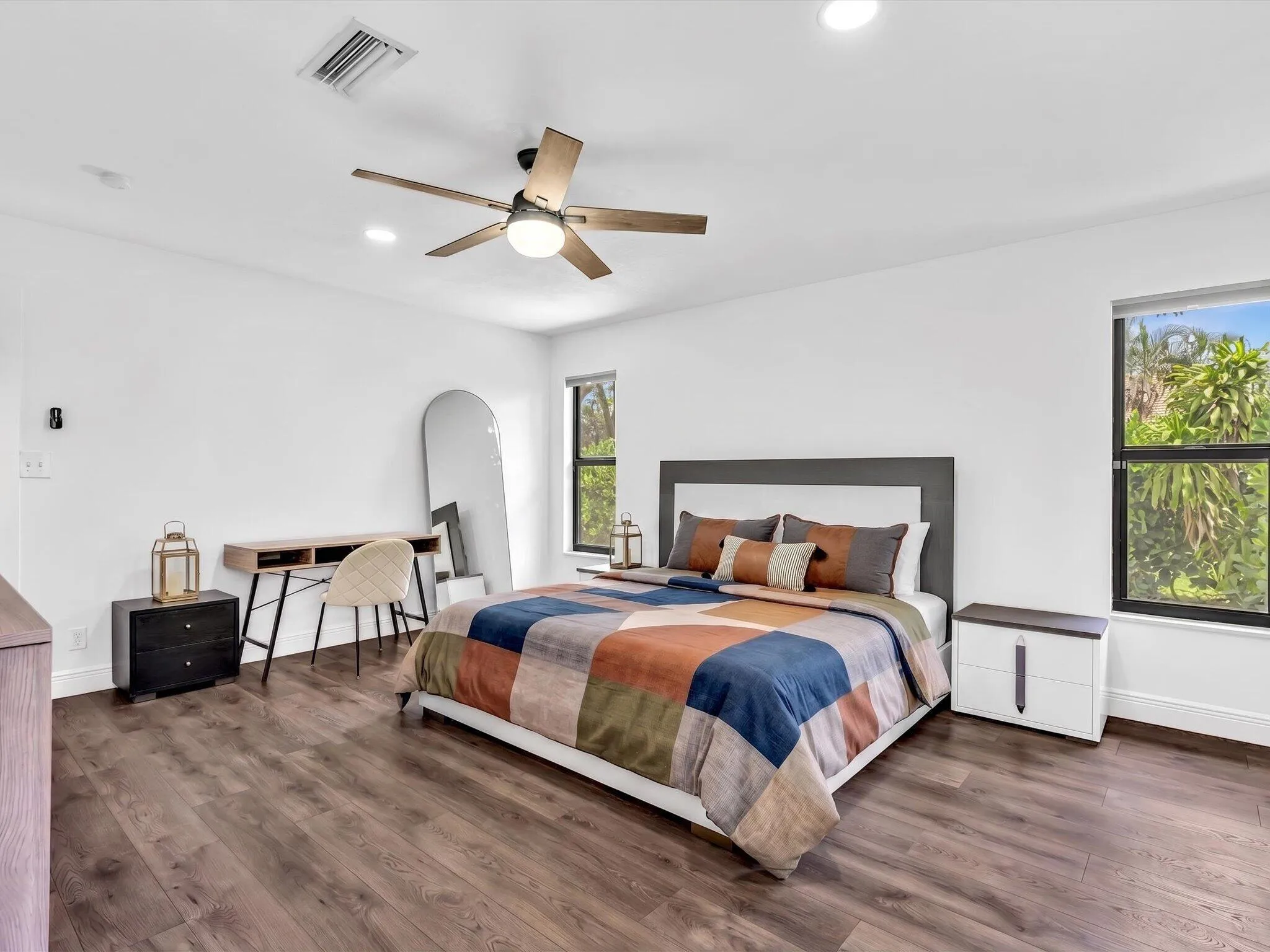 Wood-finish flooring throughout, paired with a contemporary ceiling fan and recessed lighting