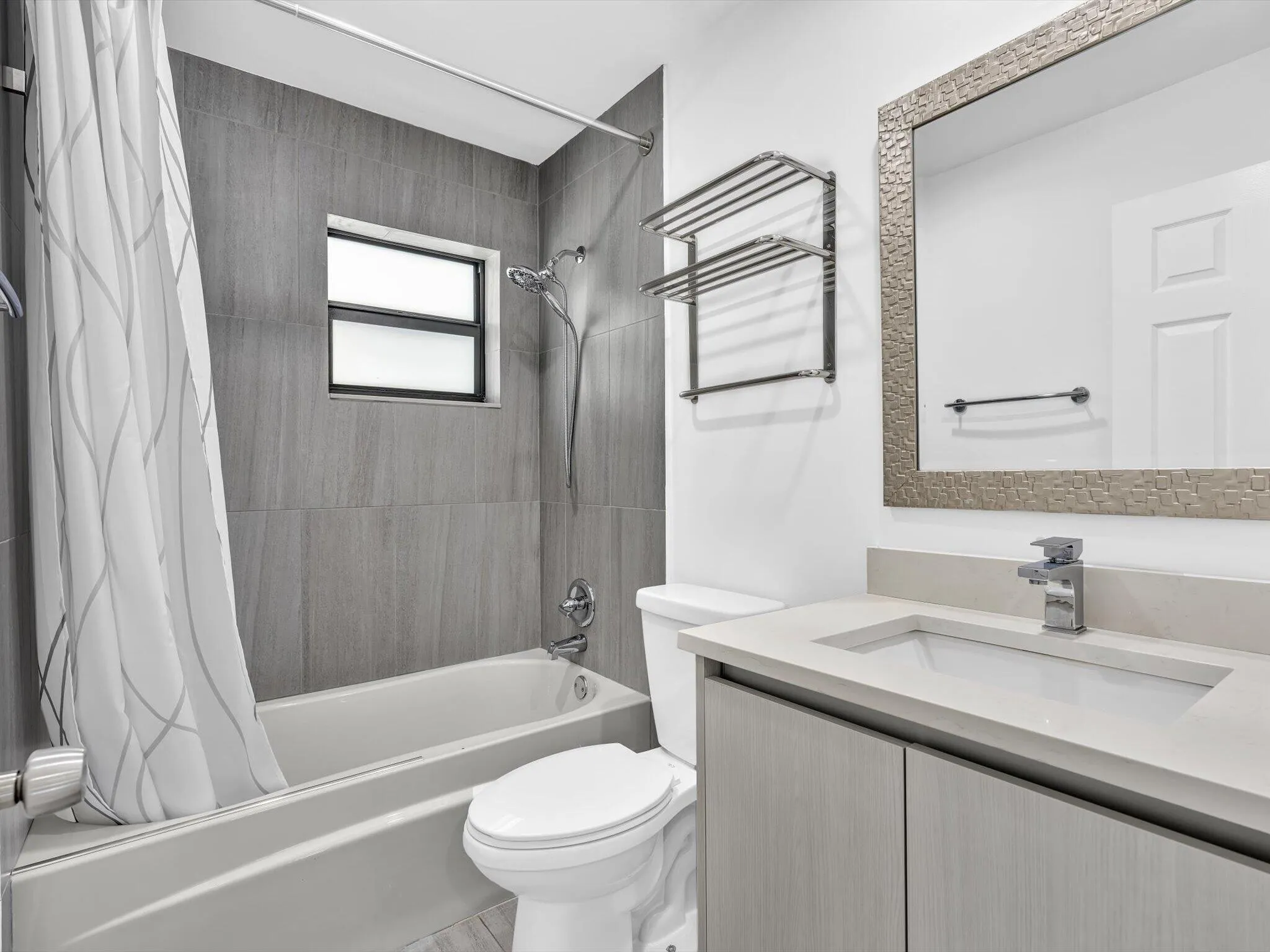 Bathroom featuring a single vanity with a light-toned countertop, an integrated sink, and an undermount cabinet
