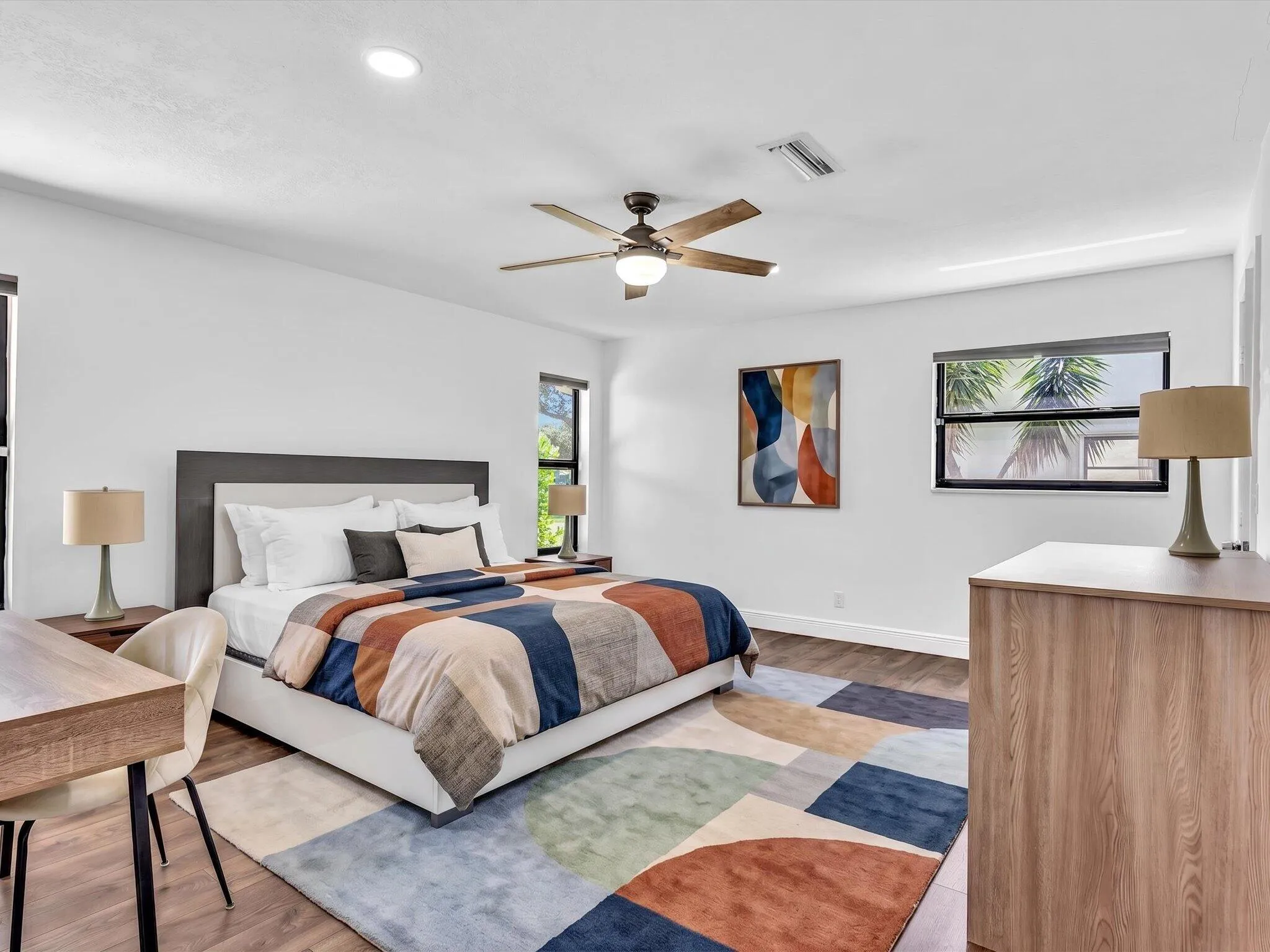 Wood-finish flooring with recessed lighting and a ceiling fan
